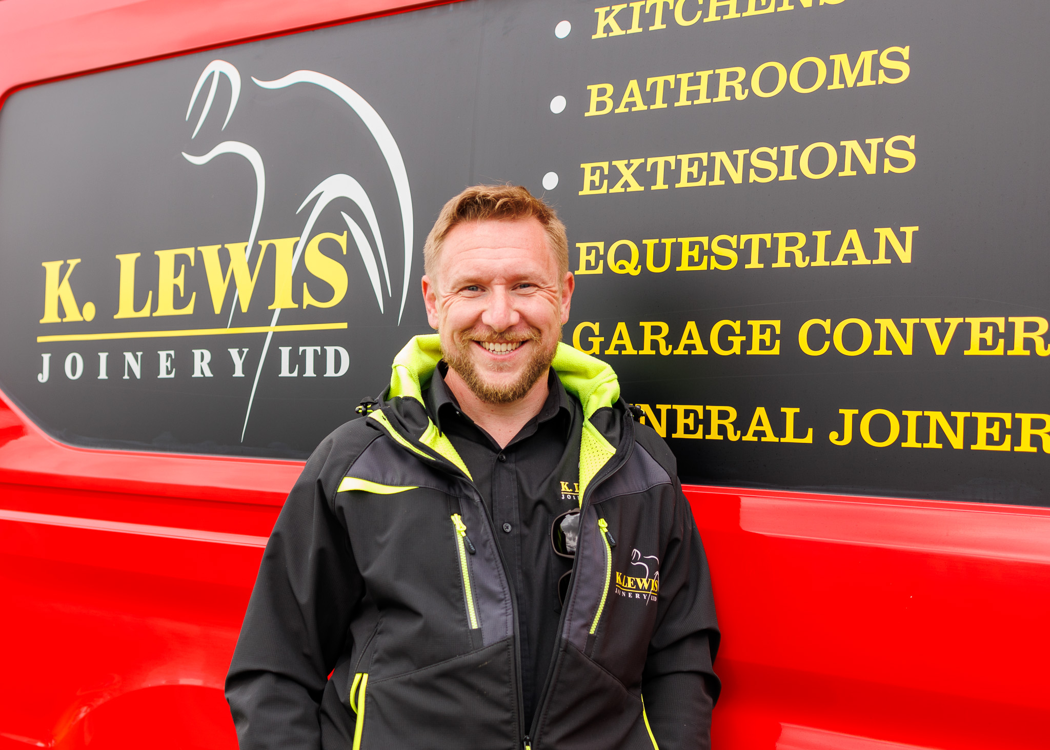 Kris Lewis, owner of K. Lewis Joinery, standing by his company van