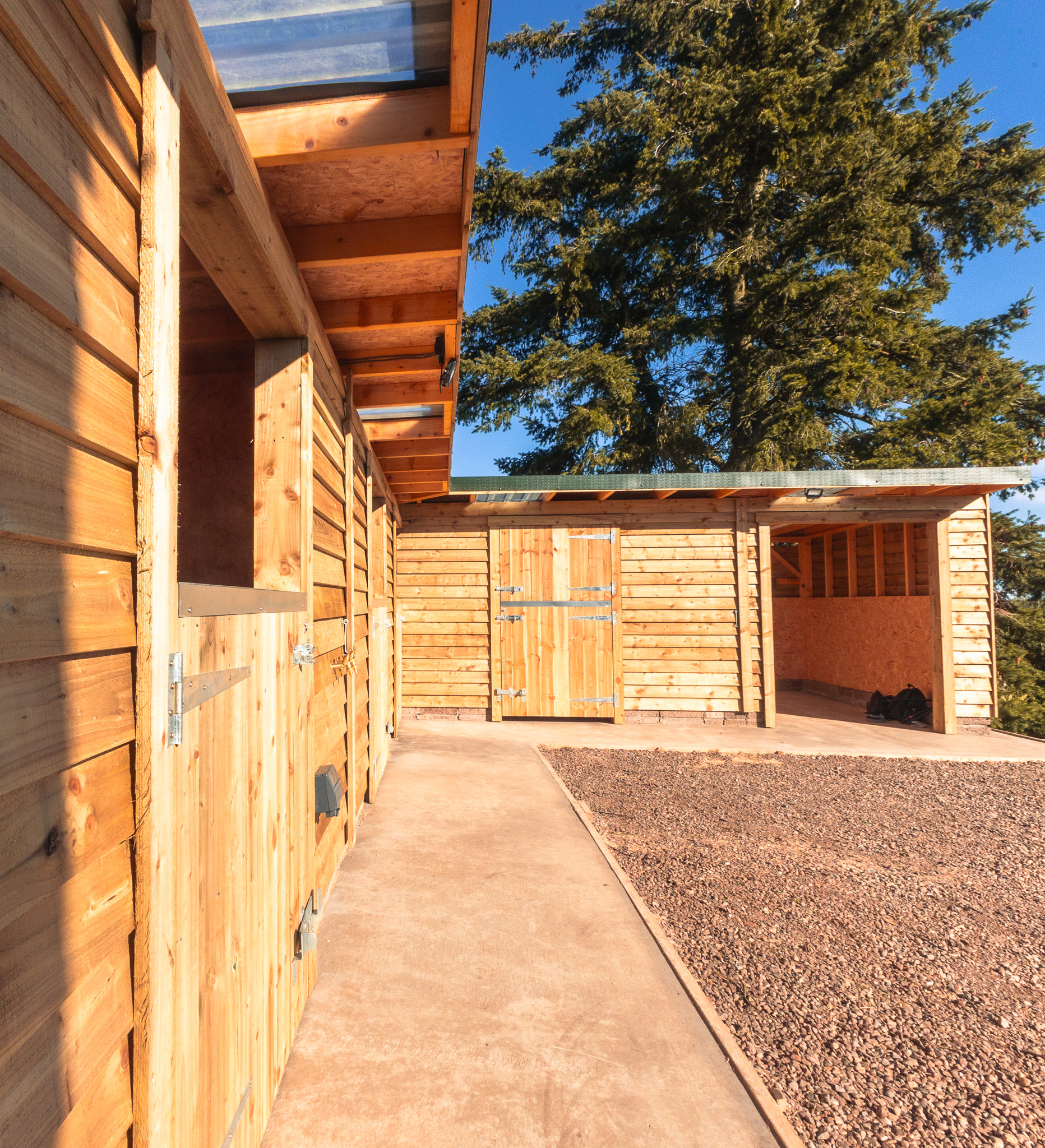 Custom equestrian stables with interior view showing quality timber construction